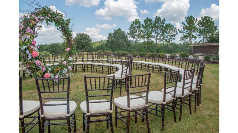 Floral arch ceremony with chiavari chairs on a golf course lawn