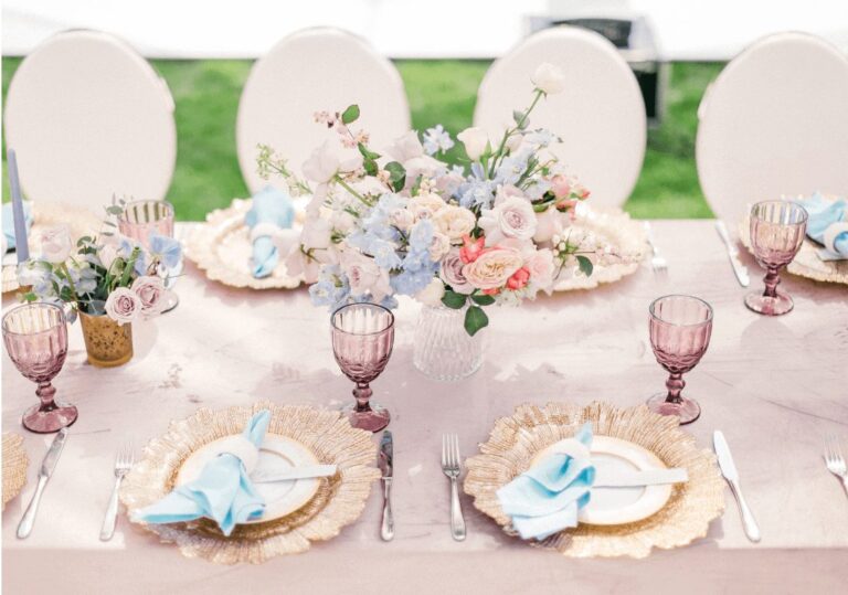 Pastel tablescape with gold chargers, pink goblets and floral centerpieces