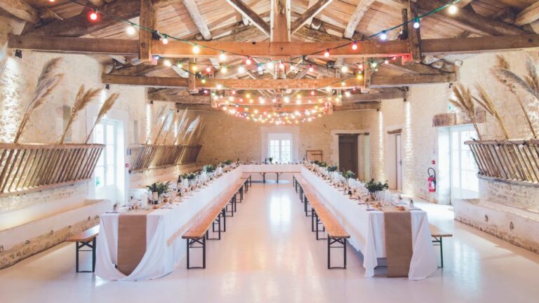 Rustic reception hall with long tables under string lights