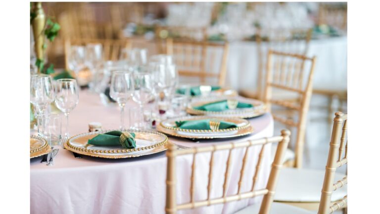 Round tables with green napkins, gold chargers and gold chiavari chairs